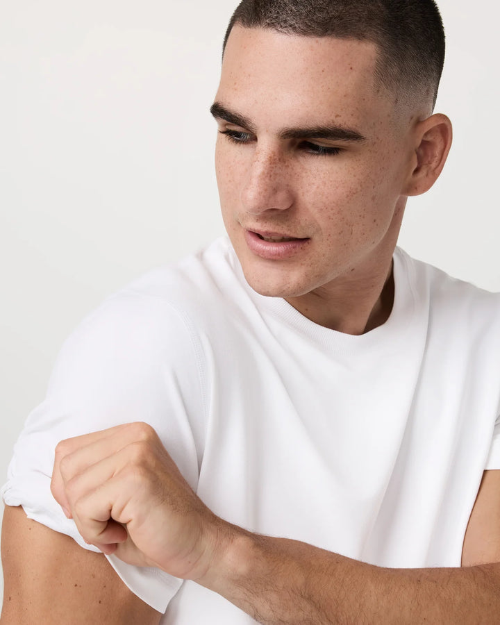 Man wearing a plain white t-shirt against a light background