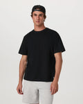 Man wearing a black t-shirt and gray shorts on a white background