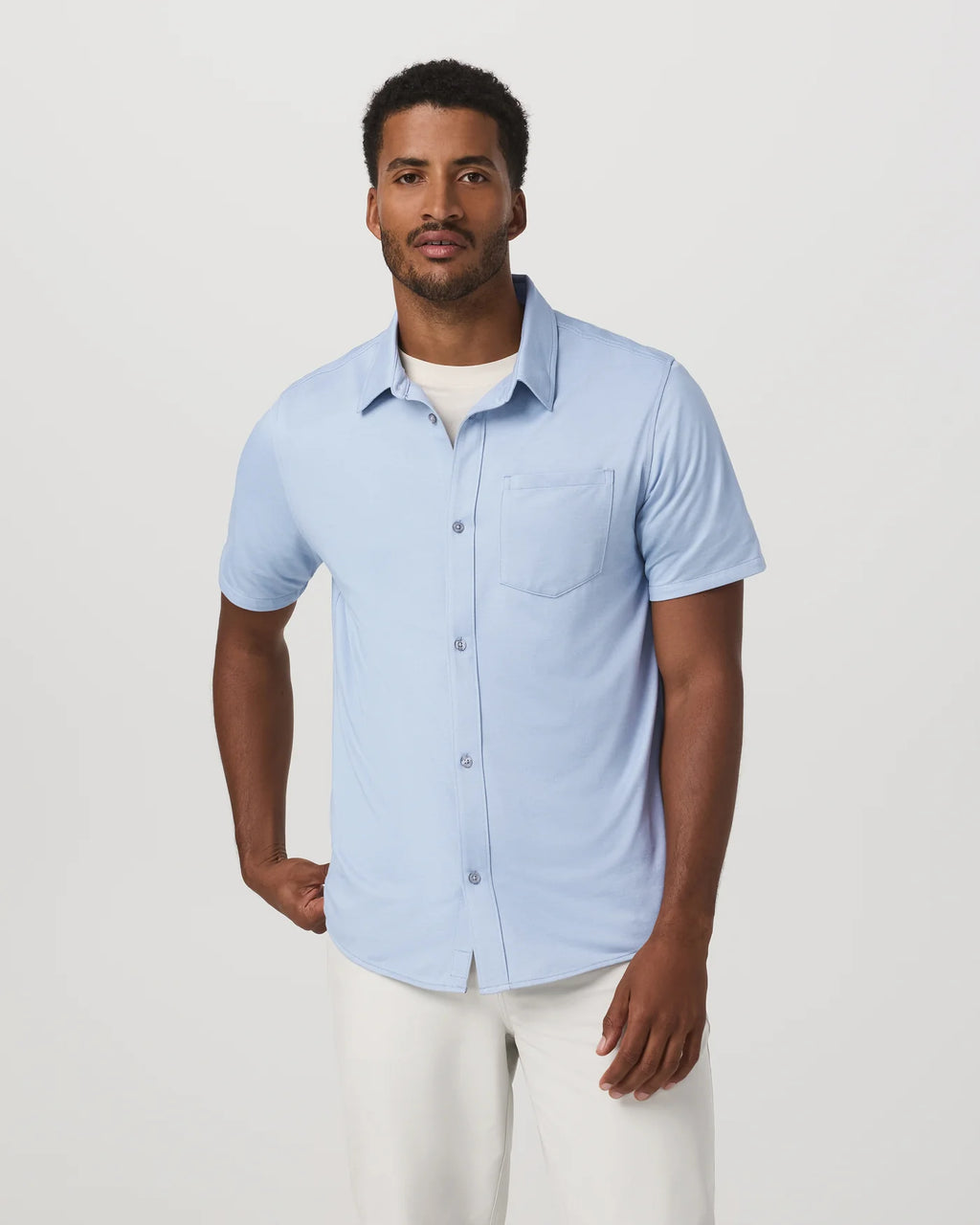 Man wearing a light blue short-sleeve shirt on a white background