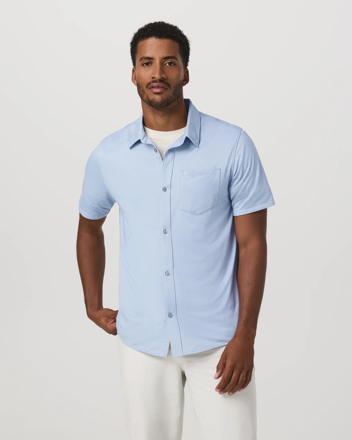 Man wearing a light blue short-sleeve shirt on a white background
