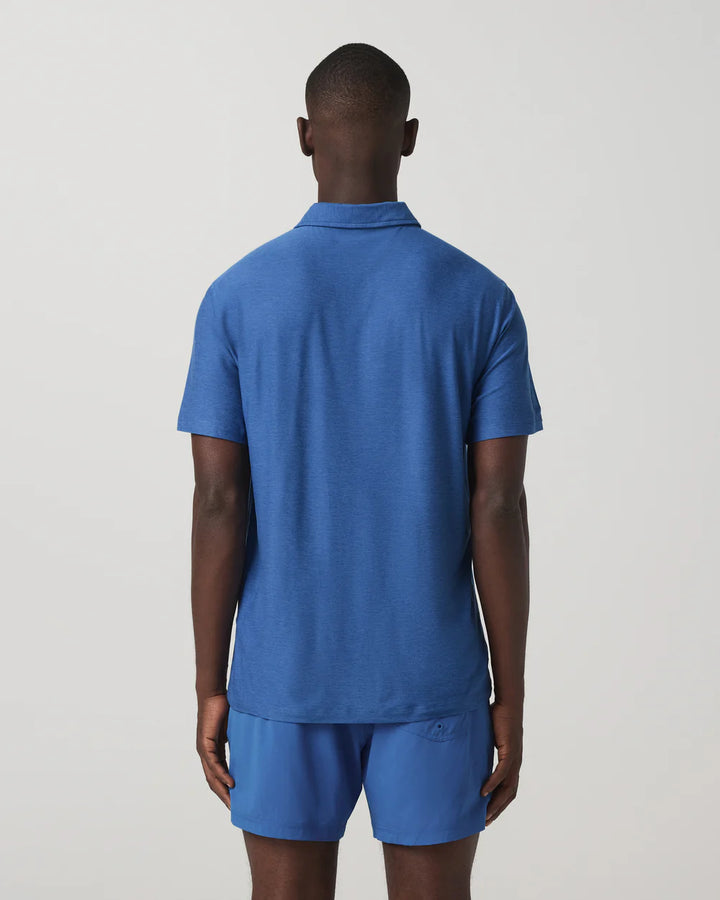 Person wearing a blue polo shirt and shorts on a plain background