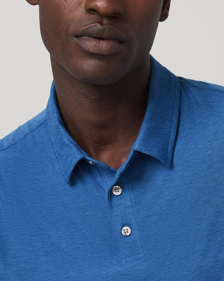 Man wearing a blue polo shirt against a neutral background