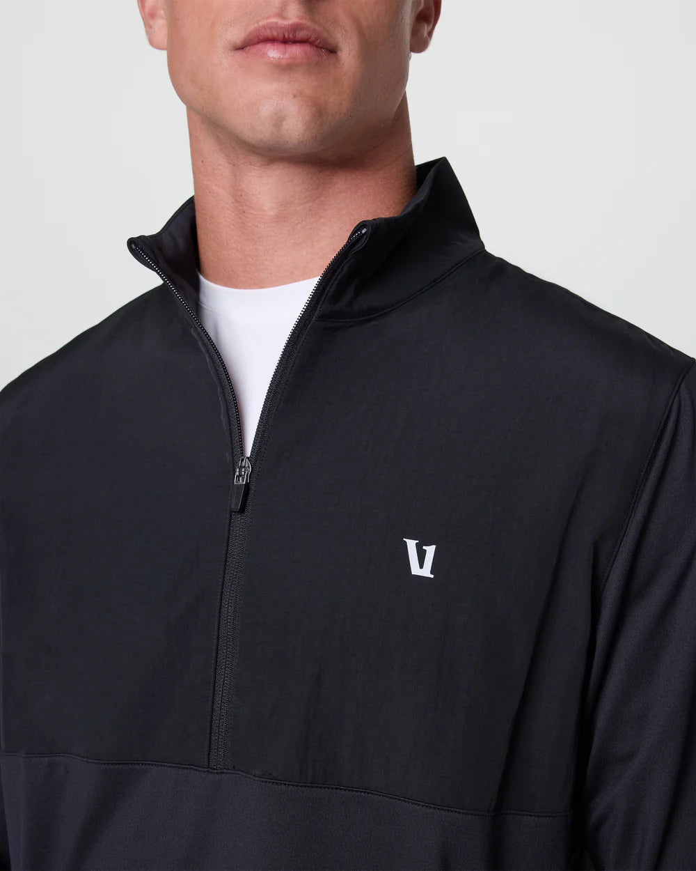 Black quarter-zip pullover with a logo on the chest against a light gray background