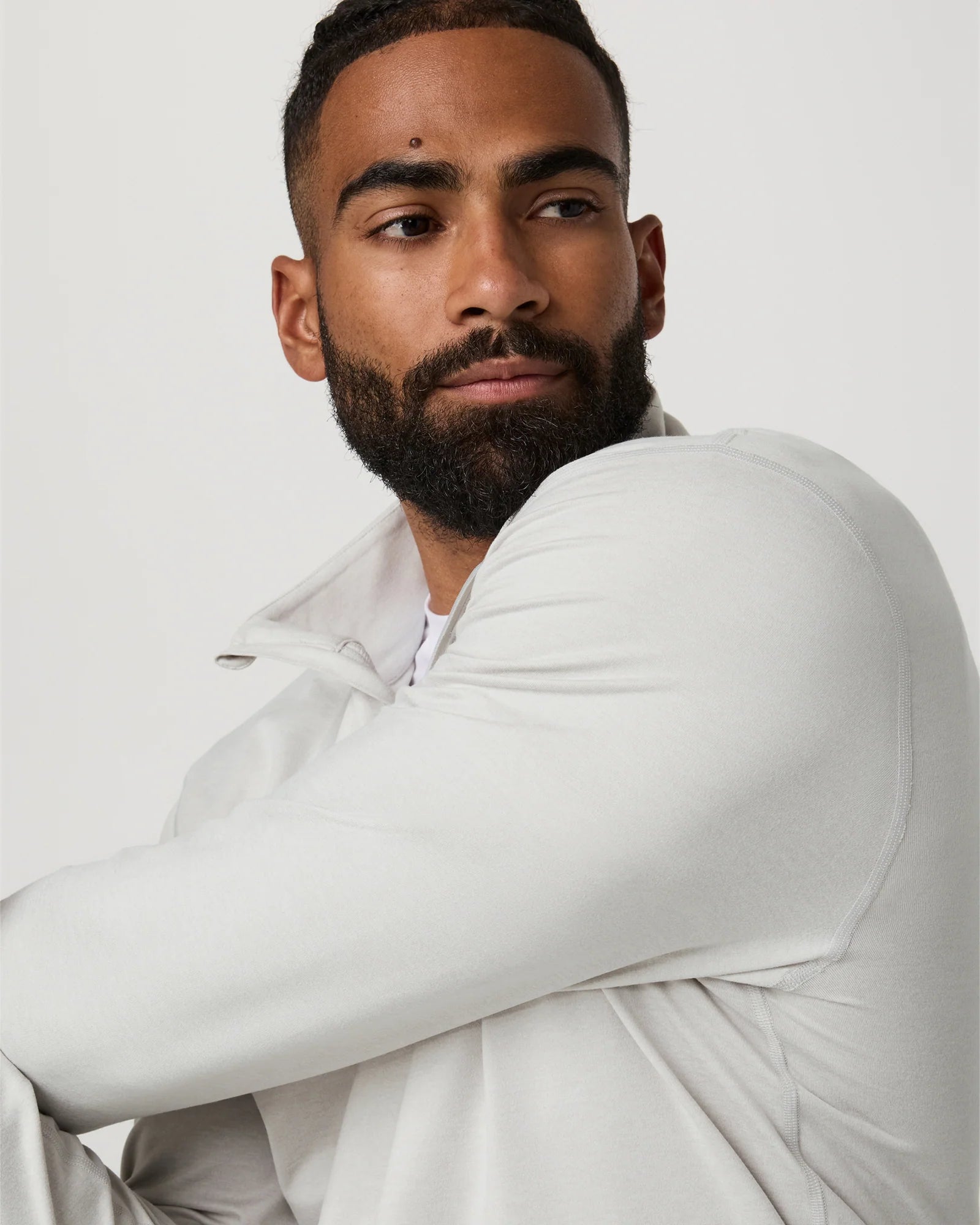 Man wearing a white outfit against a plain background