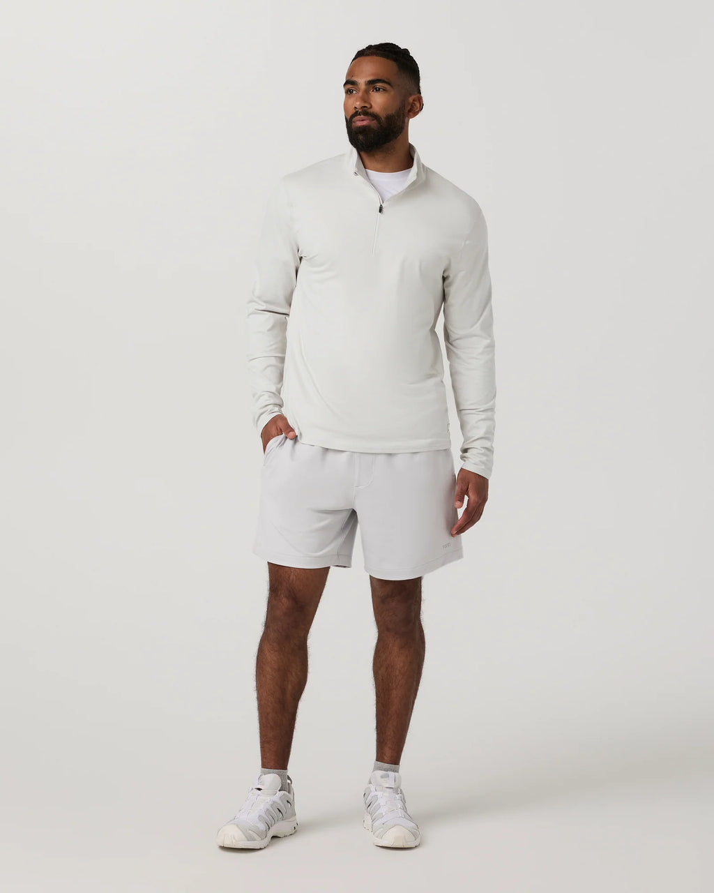 Man wearing a white long-sleeve shirt and shorts on a white background