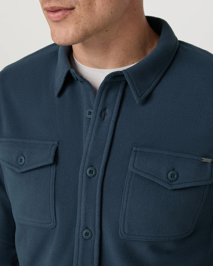 Navy blue shirt with collar and front pockets on a neutral background