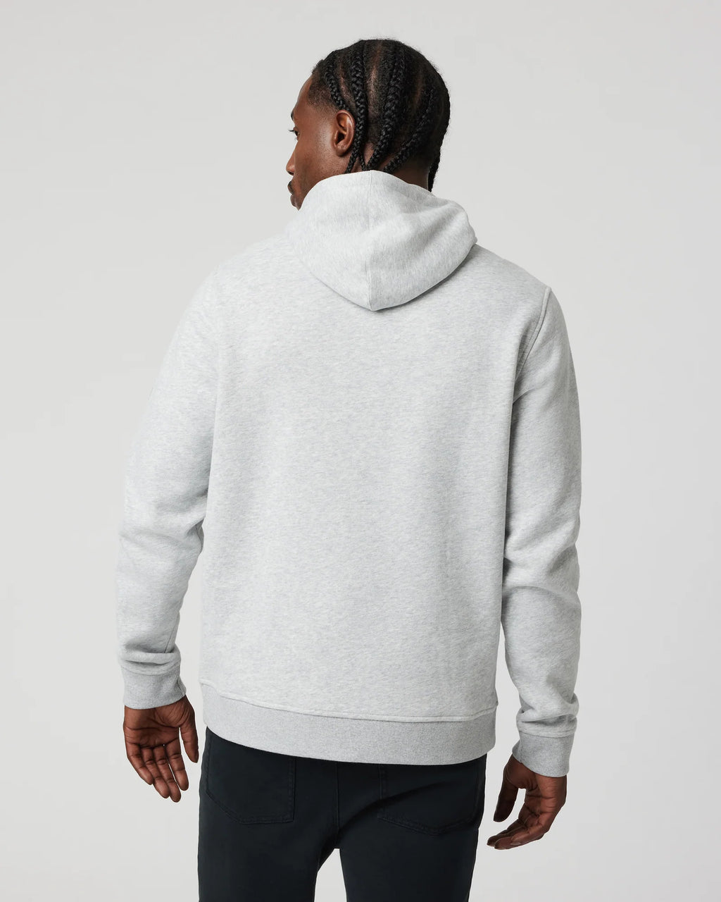Person wearing a gray hoodie from behind on a light gray background