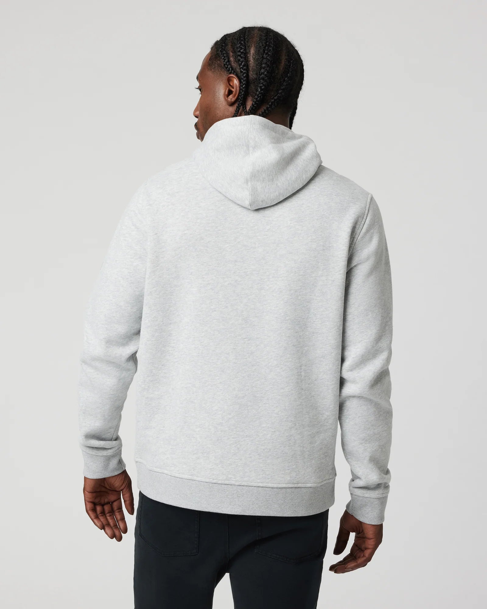 Person wearing a gray hoodie from behind on a light gray background