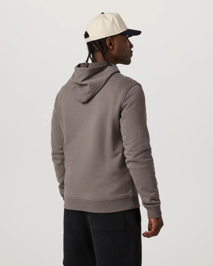 Person wearing a gray hoodie and black pants on a white background