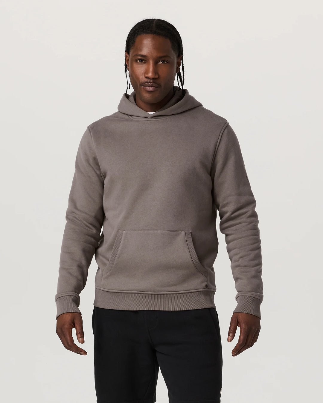 Man wearing a gray hoodie on a plain background