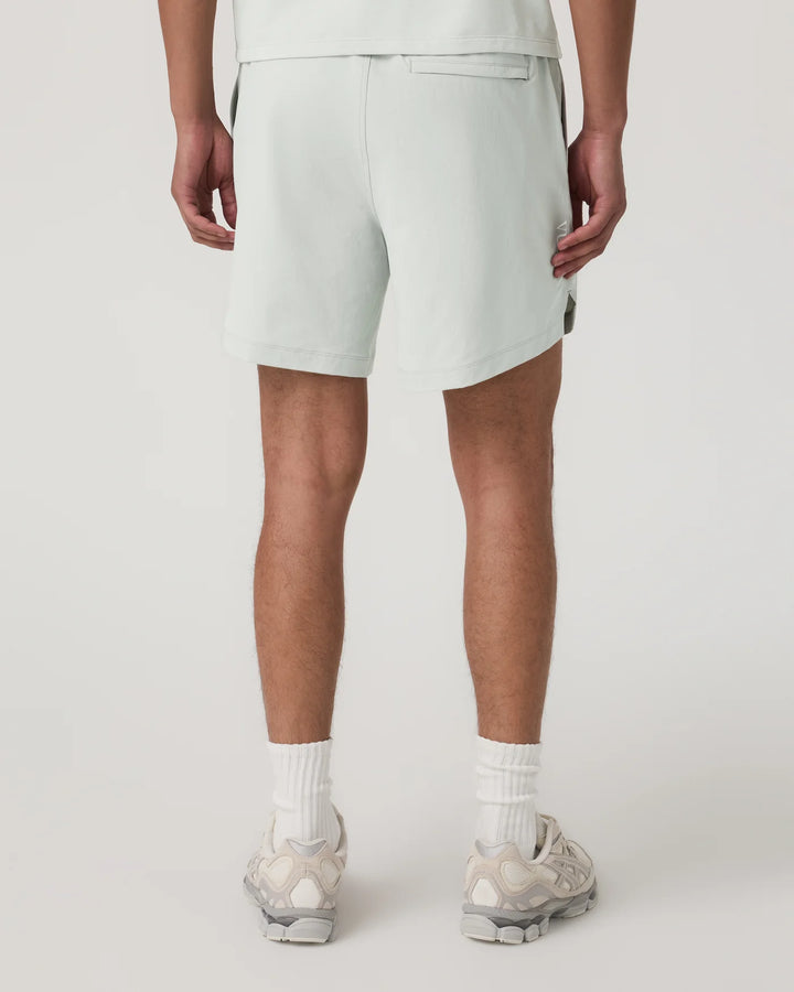 Person wearing light gray shorts on a white background
