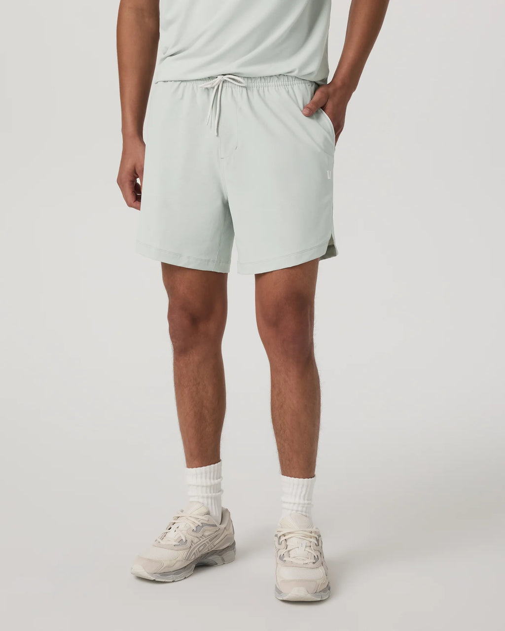 Person wearing light gray shorts on a plain background