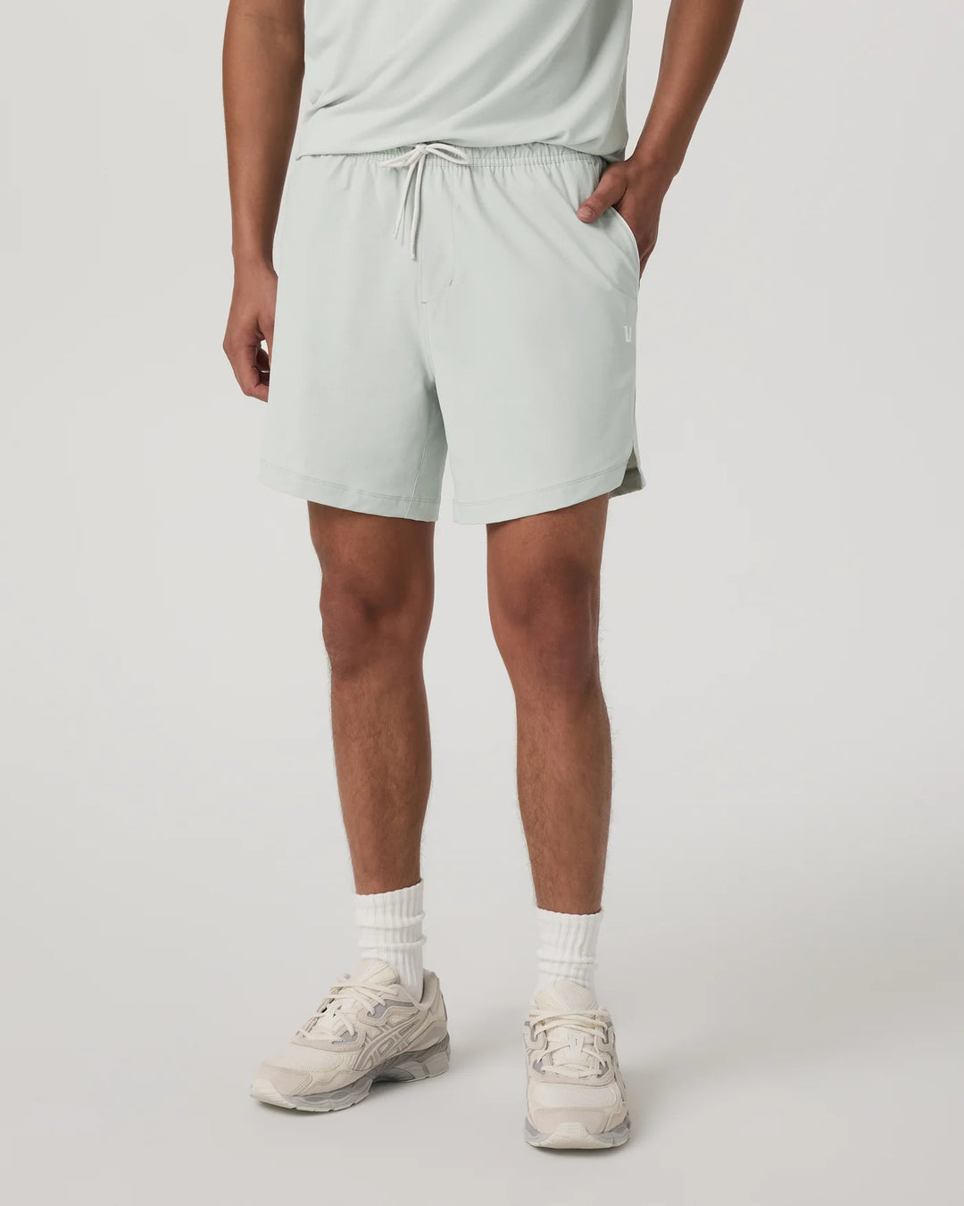 Person wearing light gray shorts on a plain background