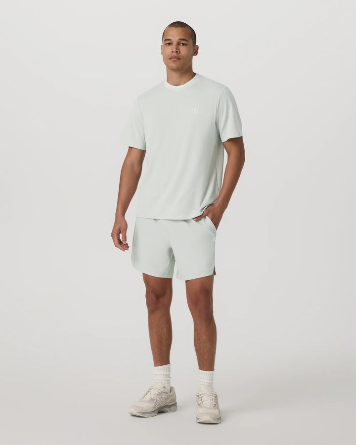 Man wearing a light green t-shirt and shorts set on a white background