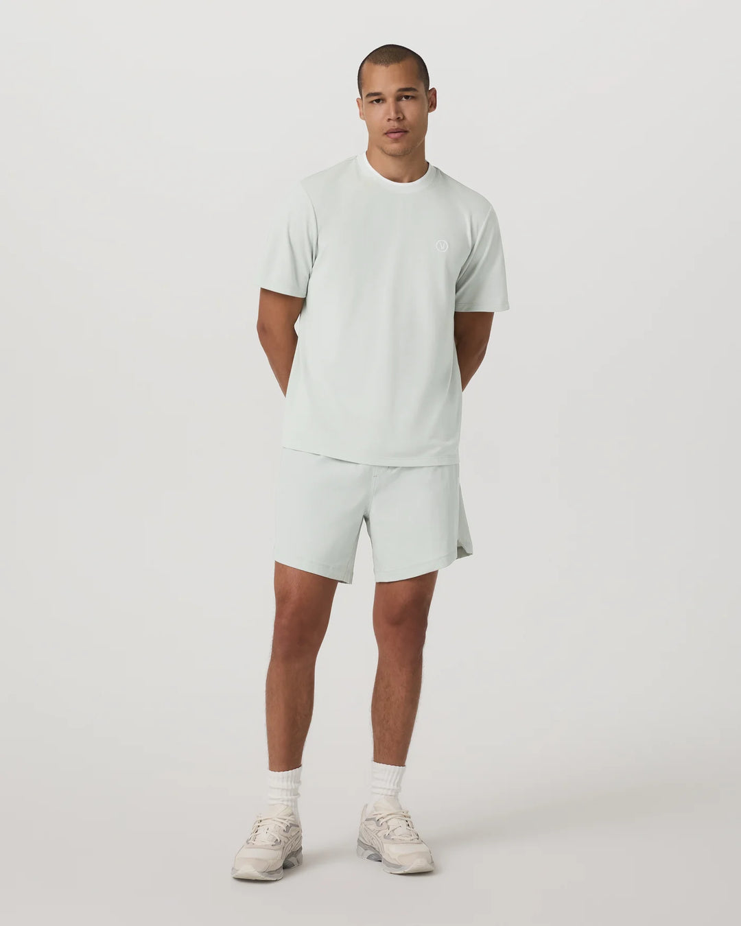 Man wearing a light gray t-shirt and shorts set on a white background