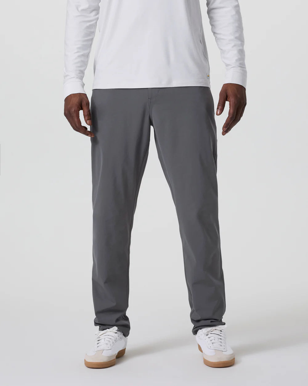 Person wearing gray pants and a white long-sleeve shirt on a light gray background