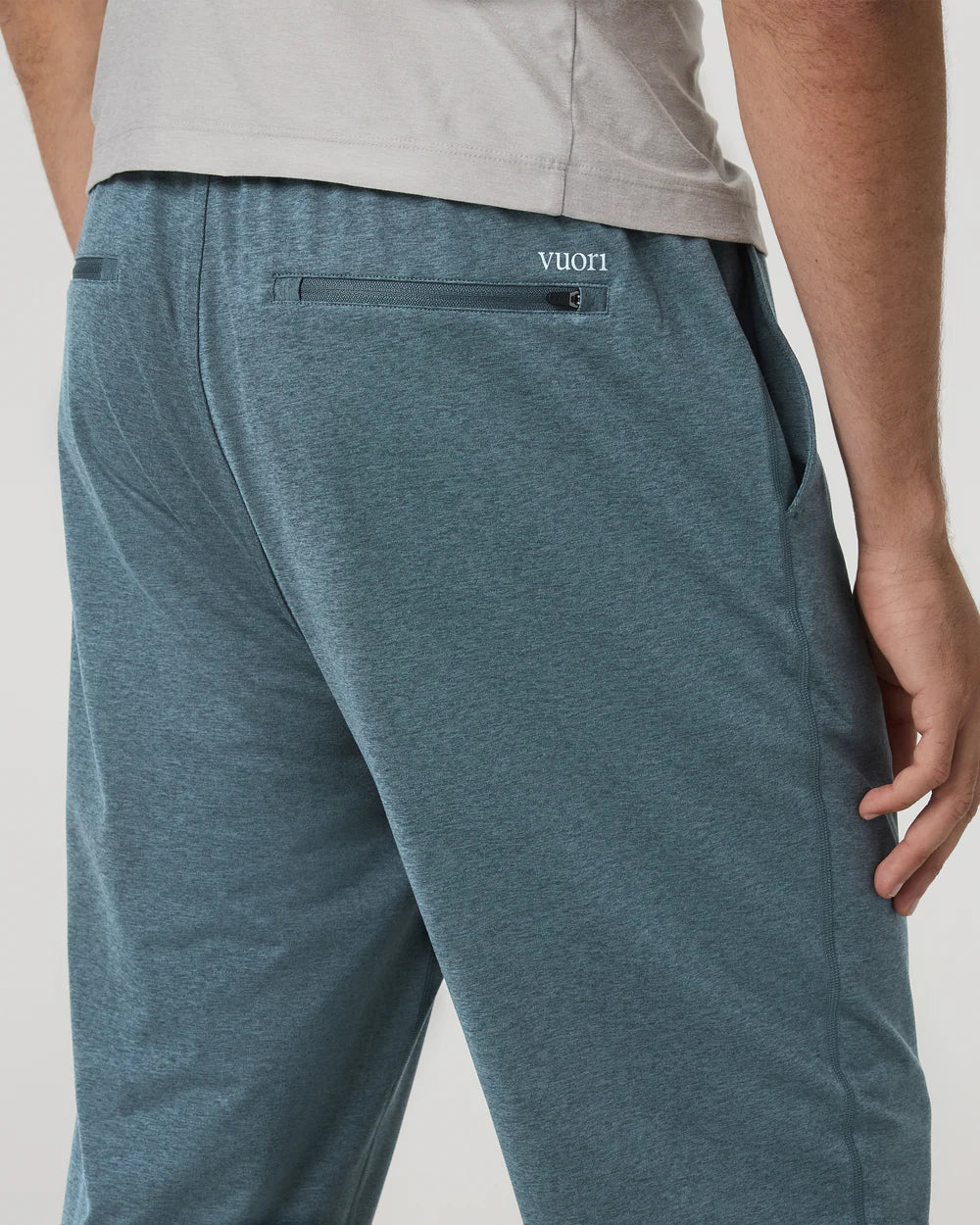 Teal pants with a brand logo on a neutral background