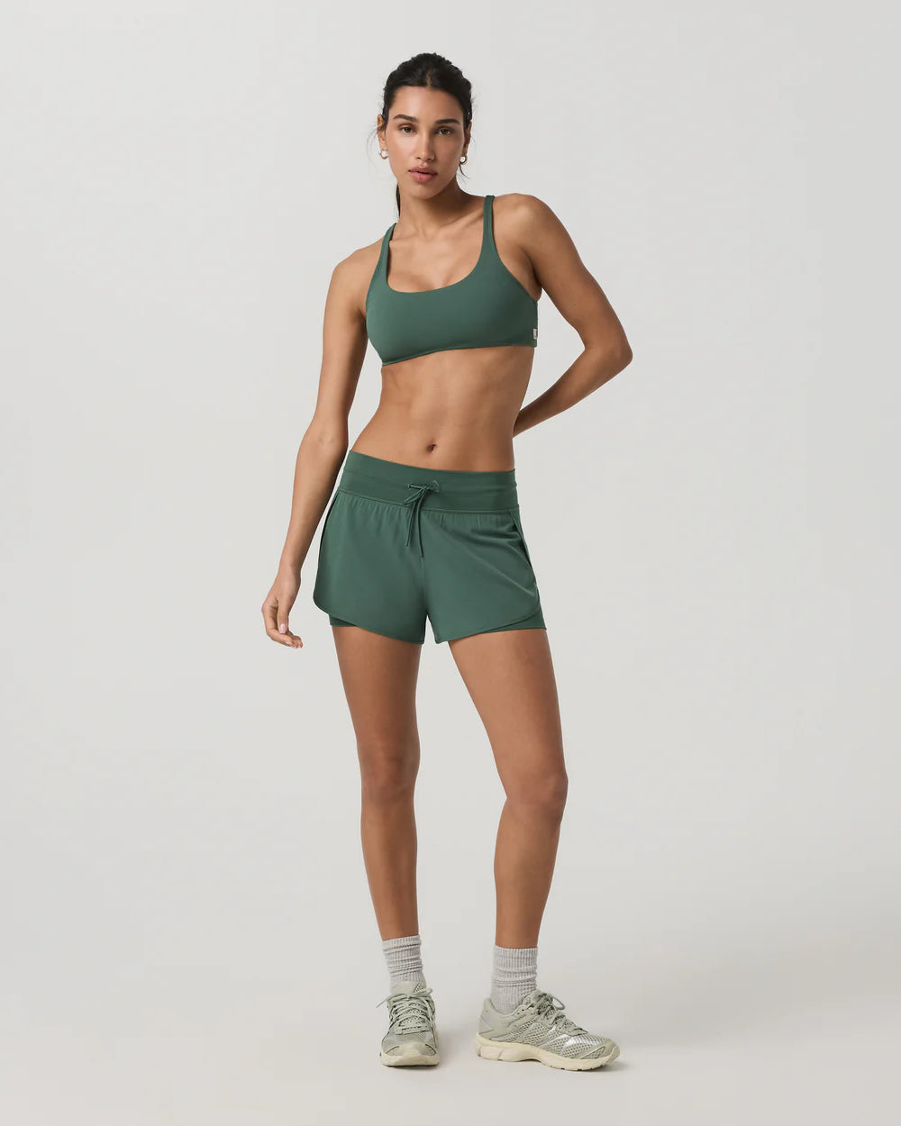 Woman wearing a green athletic outfit on a white background