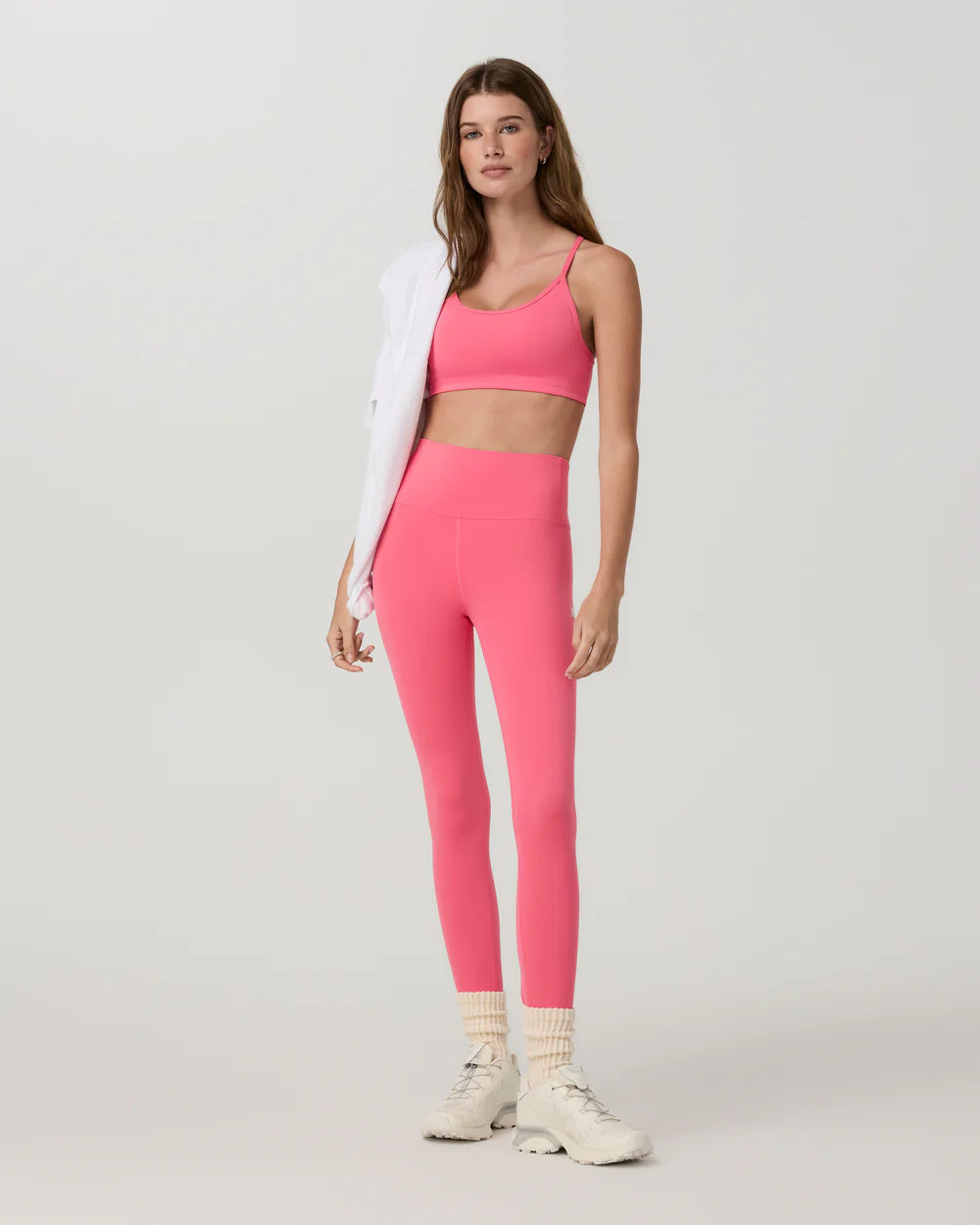Woman wearing a pink athletic outfit on a white background