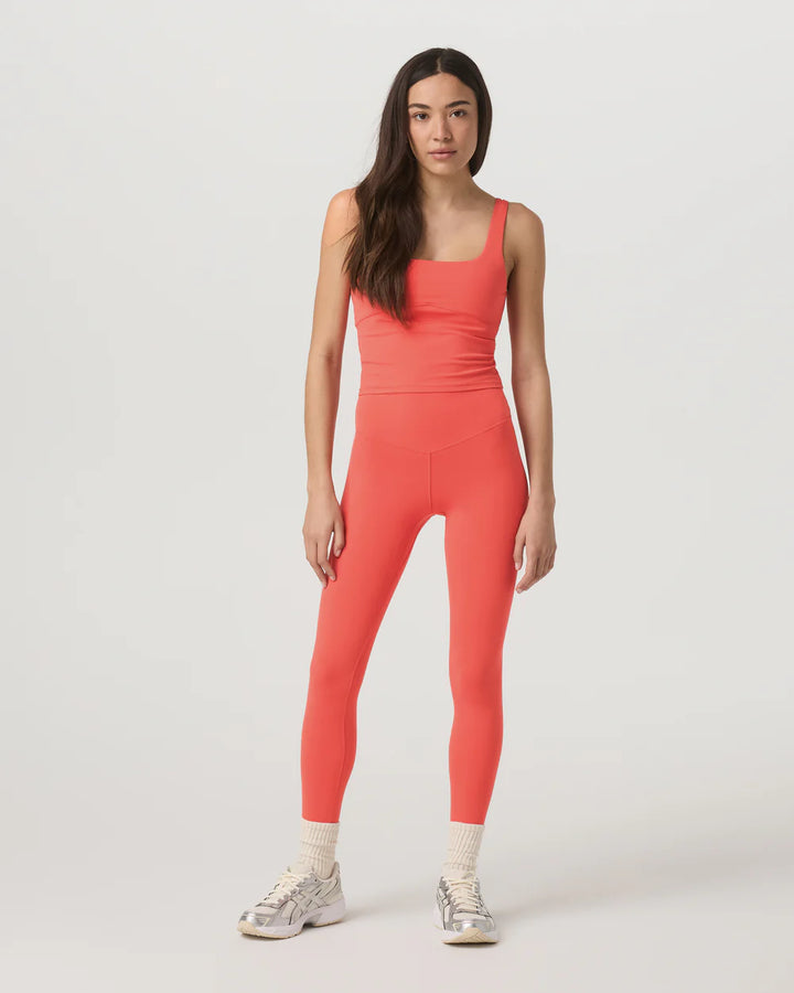 Woman wearing a coral jumpsuit on a white background