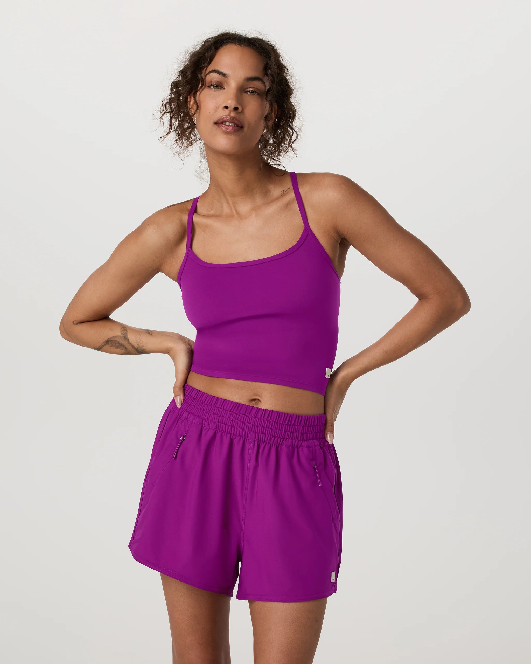 Woman wearing a purple athletic outfit on a light gray background