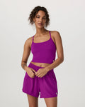 Woman wearing a purple athletic outfit on a plain background
