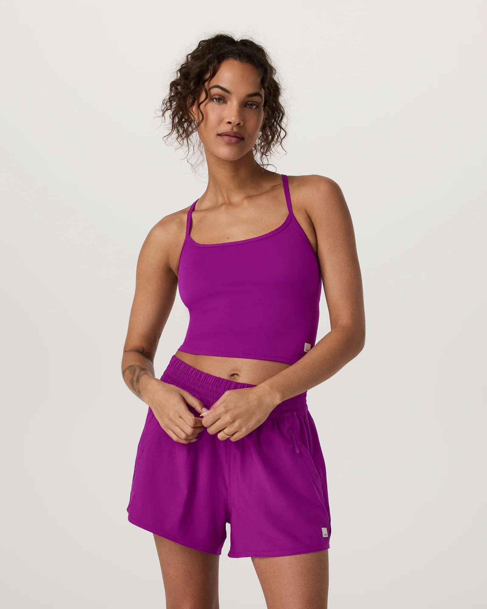 Woman wearing a purple athletic outfit on a plain background