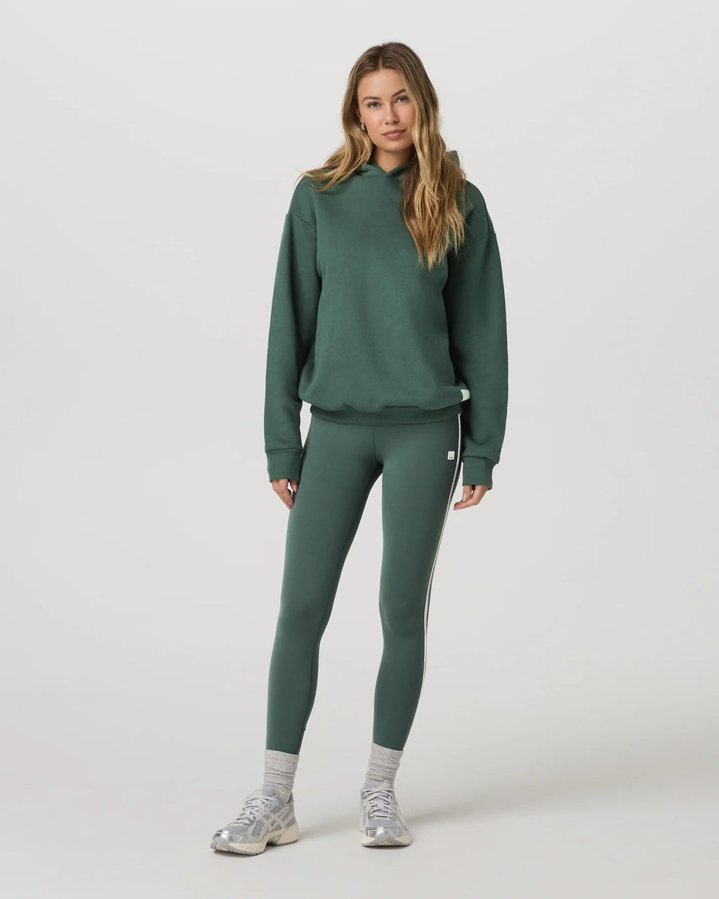 Woman wearing a green tracksuit on a white background