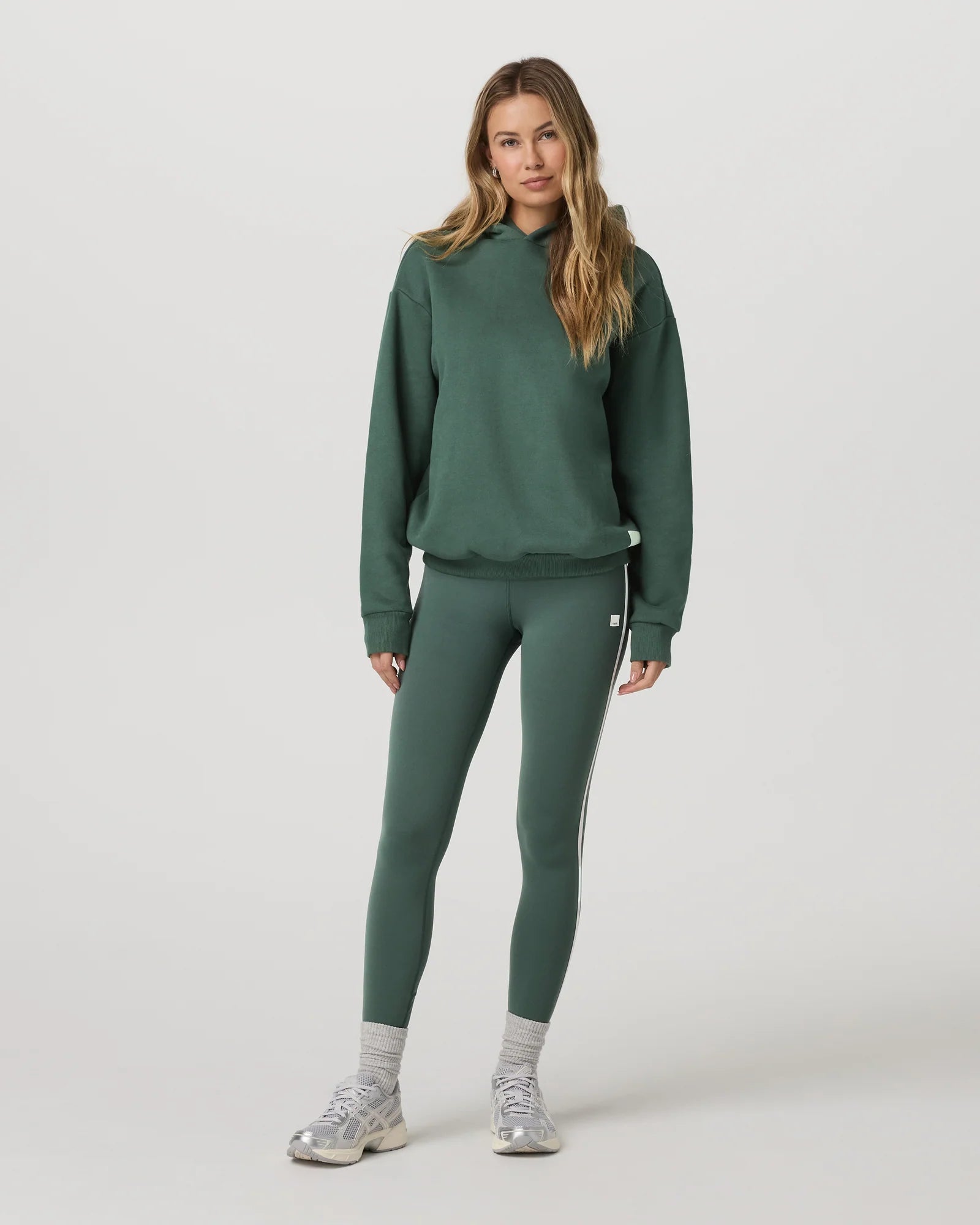 Woman wearing a green tracksuit on a white background