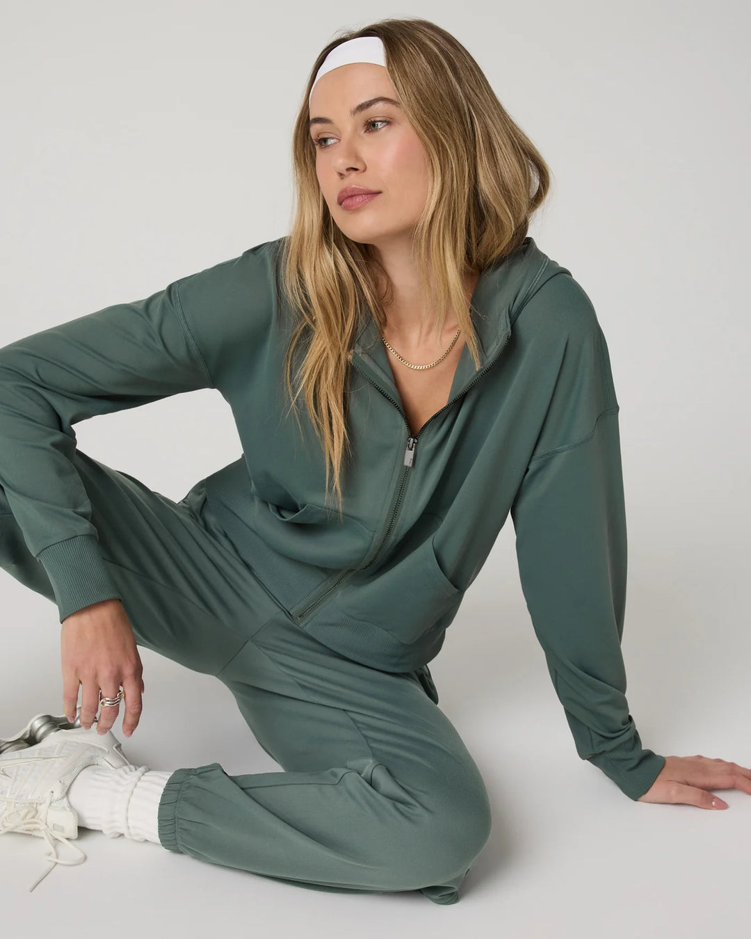 Woman wearing a green tracksuit on a white background