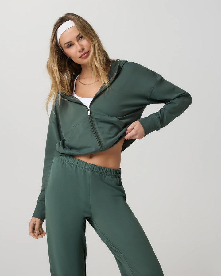 Woman wearing a green tracksuit on a plain background