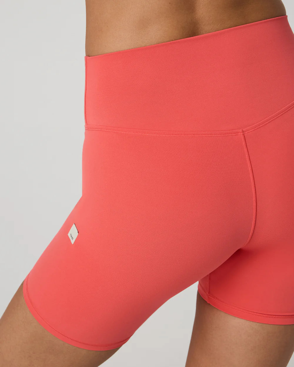 Coral pink athletic shorts on a neutral background
