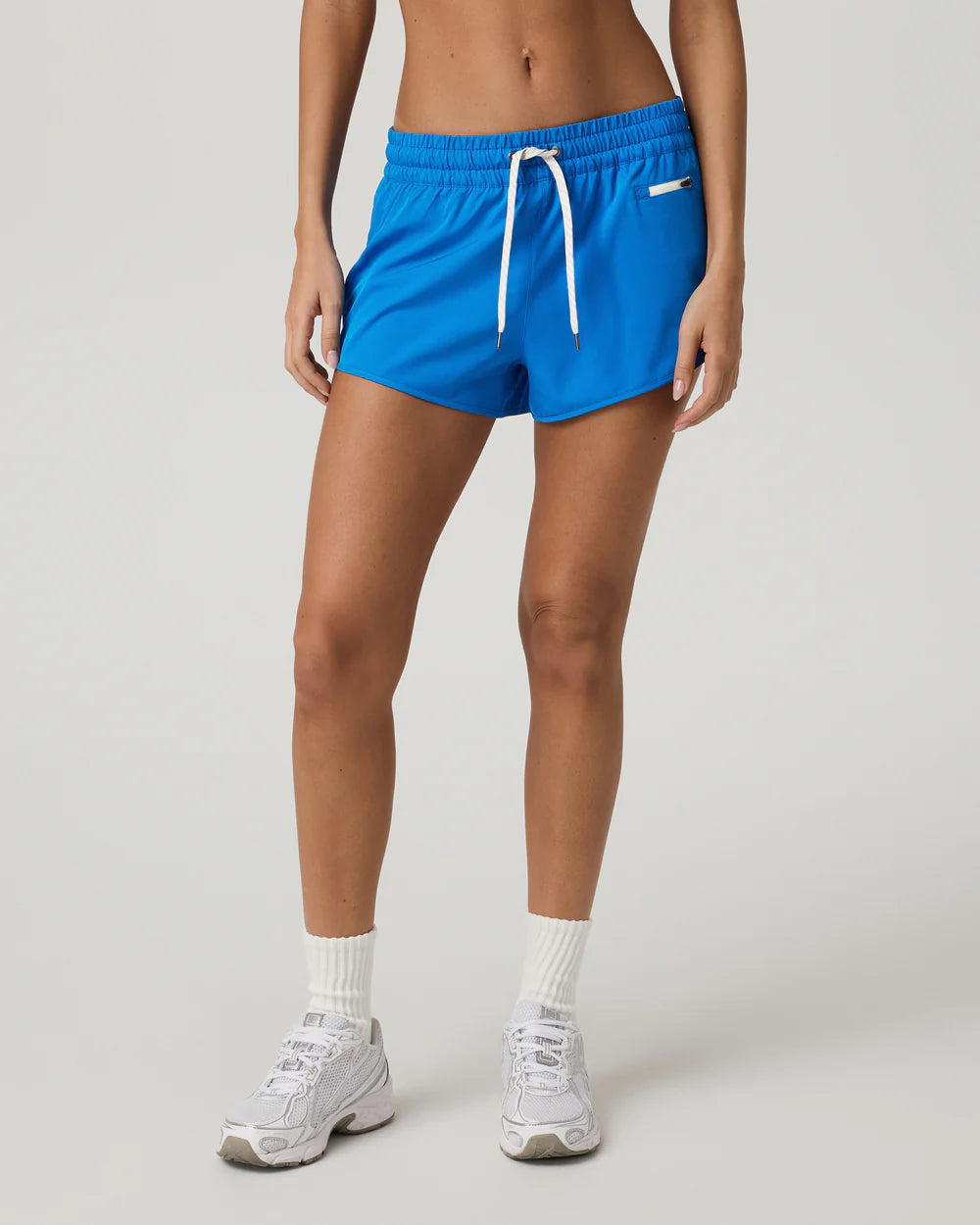 Person wearing blue shorts with a white drawstring on a light gray background