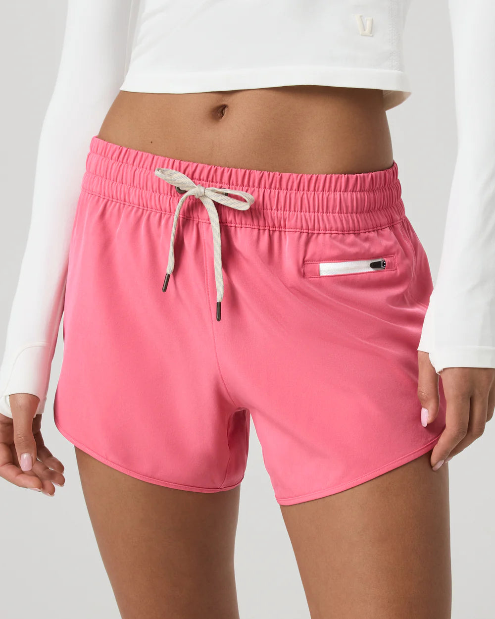 Pink shorts with a drawstring and white pocket on a plain background