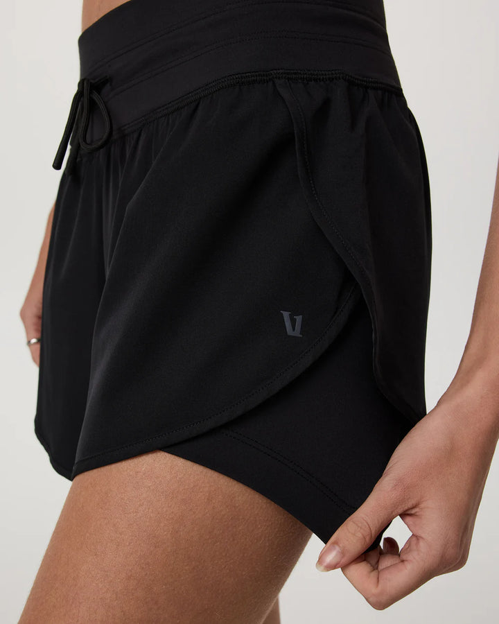 Black athletic shorts with a brand logo on a neutral background