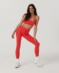 Woman wearing a red athletic outfit on a white background
