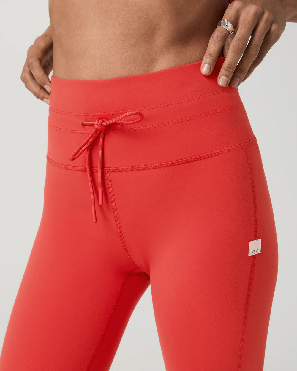Red leggings with a drawstring waistband on a plain background