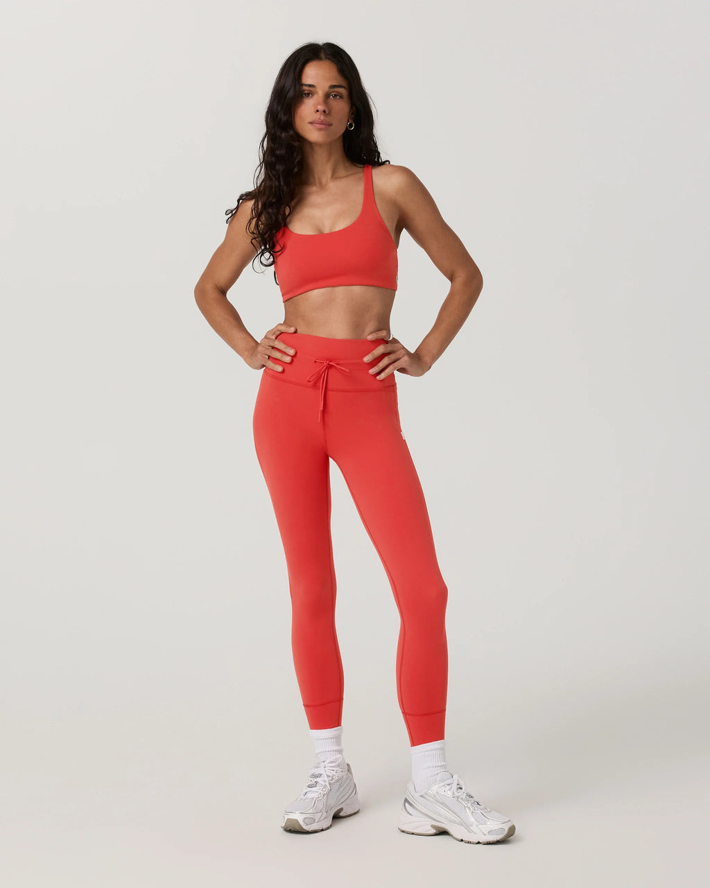 Woman wearing a red athletic outfit on a light gray background