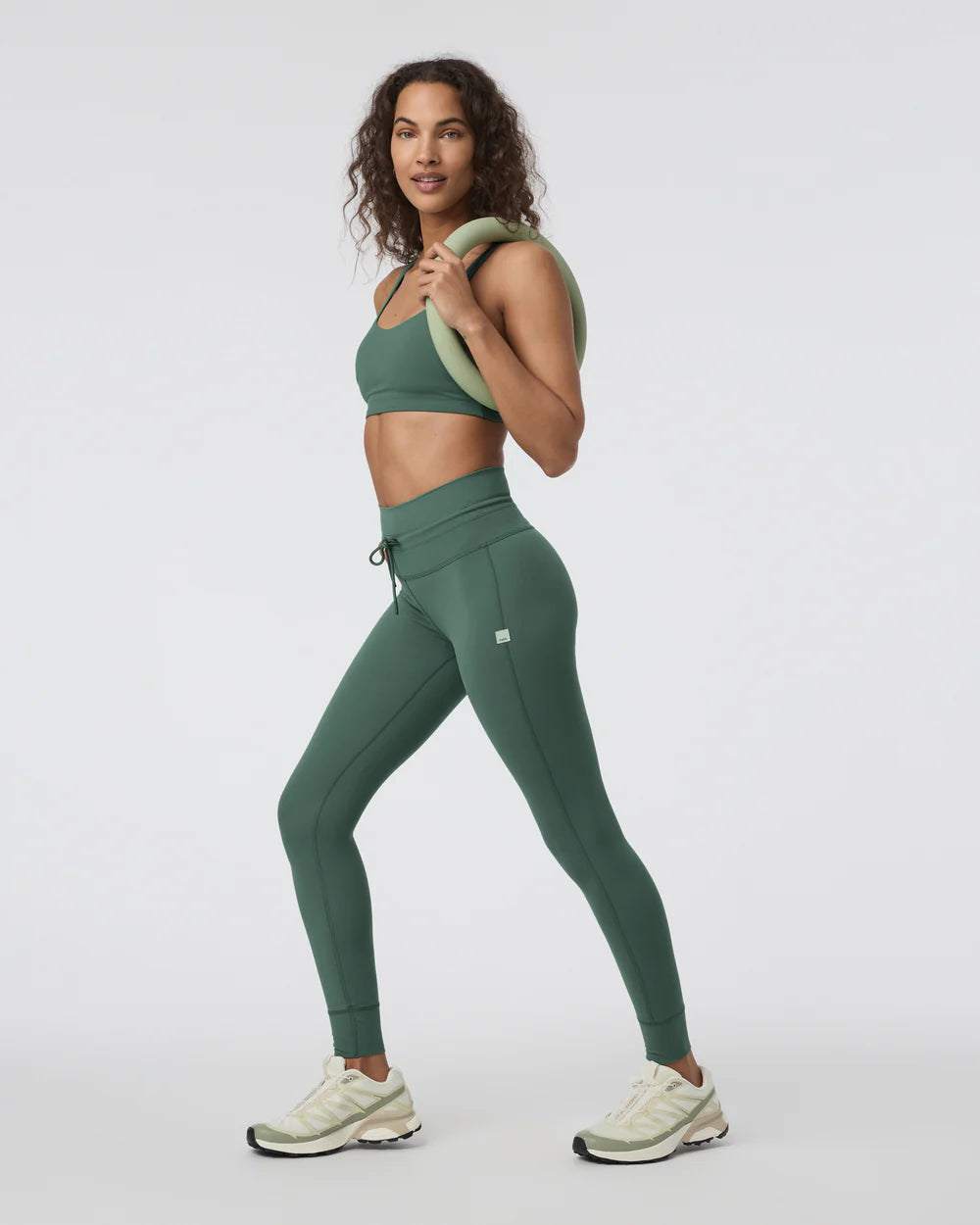 Woman wearing a green athletic outfit on a white background