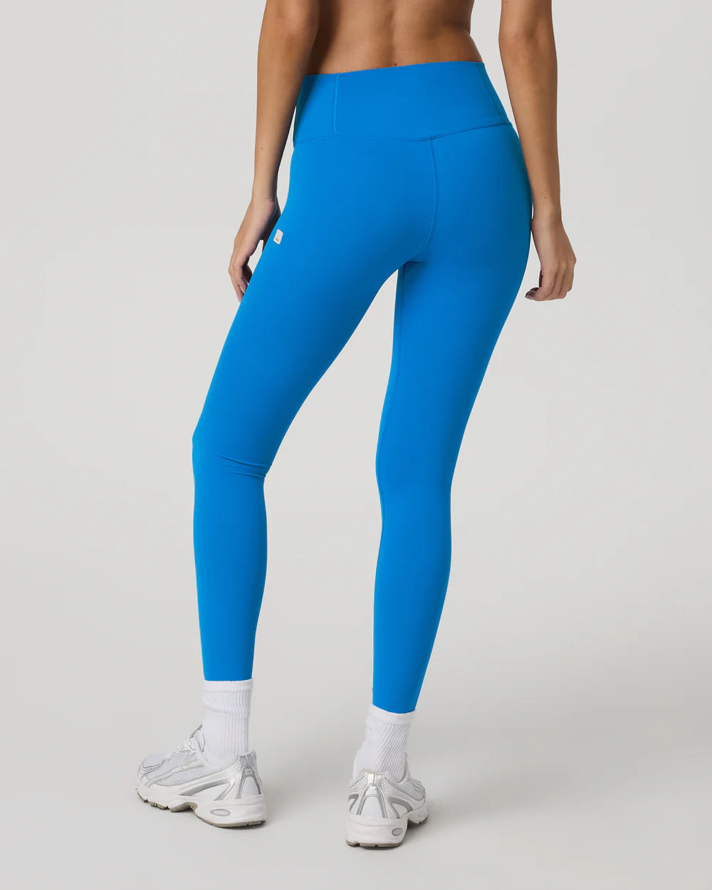 Person wearing bright blue leggings on a light gray background