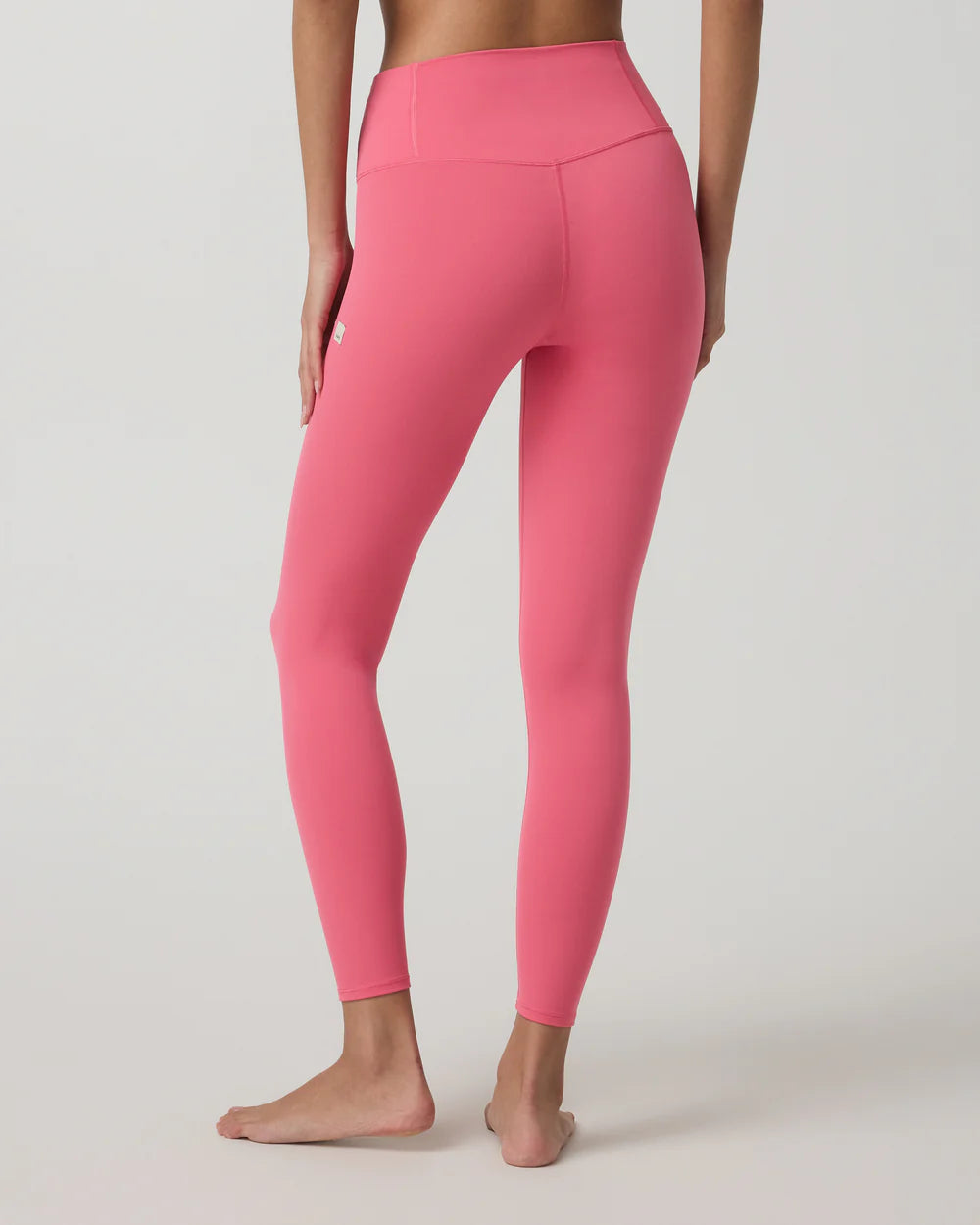 Person wearing bright pink leggings on a light gray background