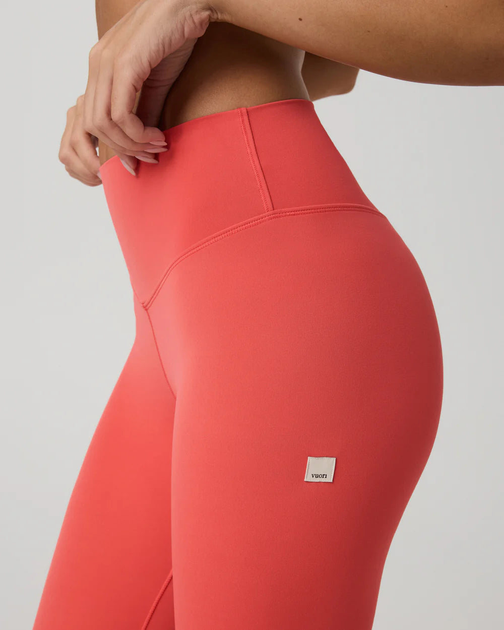 Coral leggings with a brand logo on a plain background