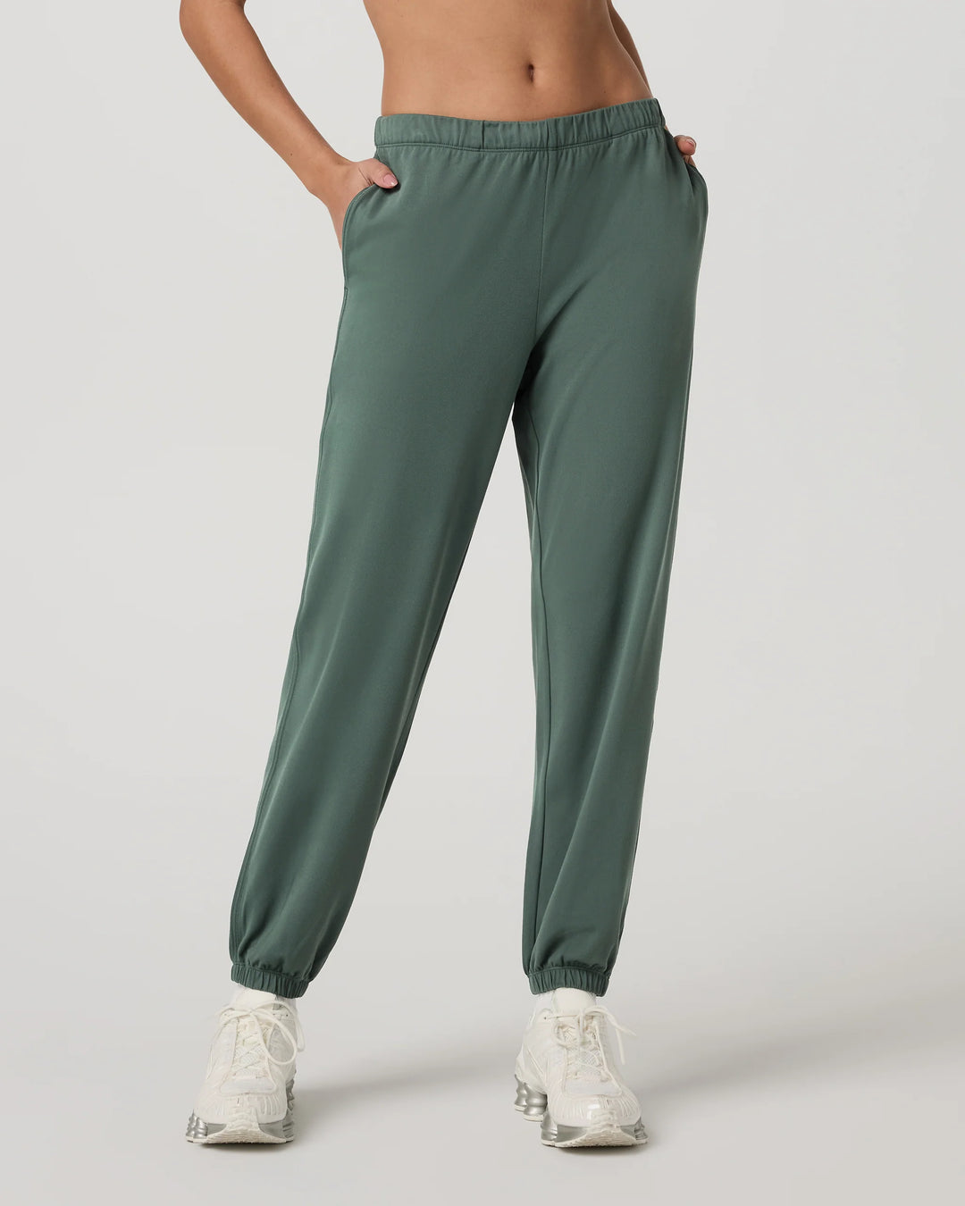 Green sweatpants worn by a person on a light gray background