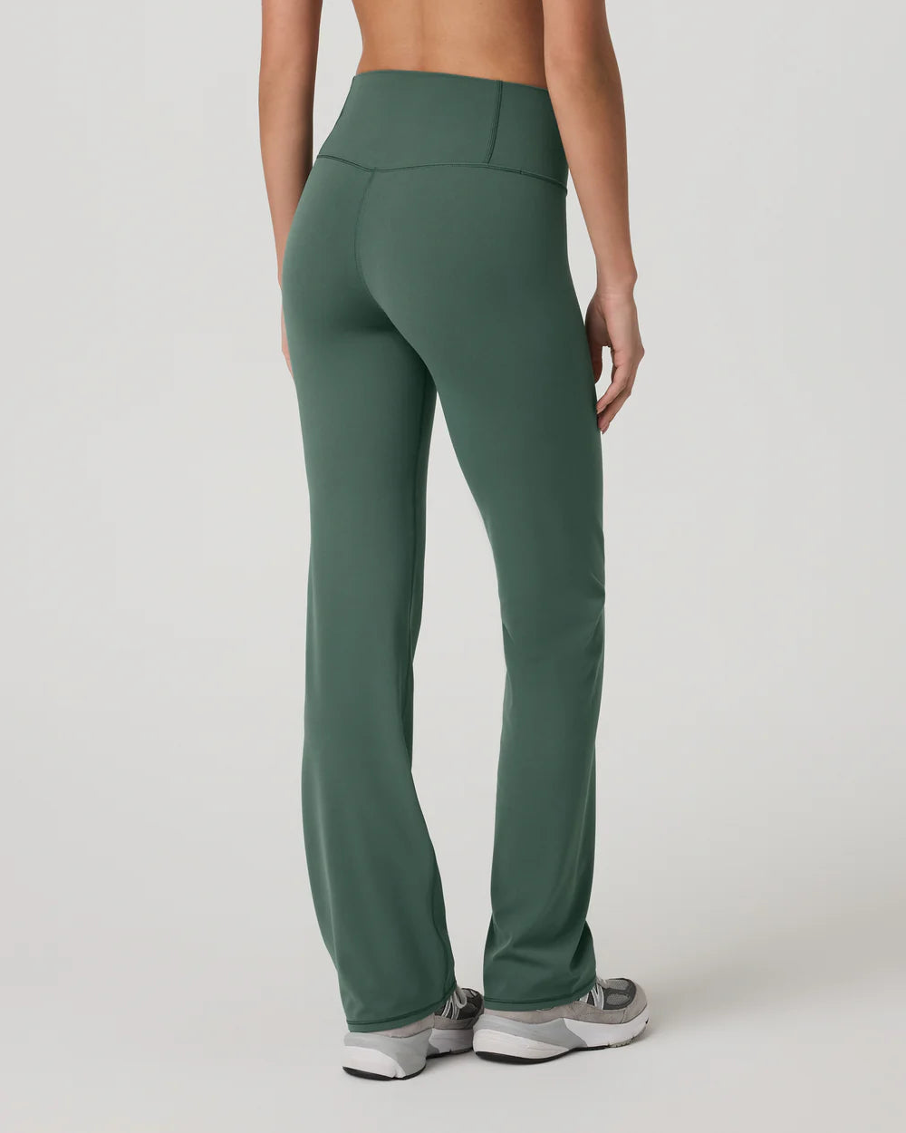 Green pants worn by a person on a white background
