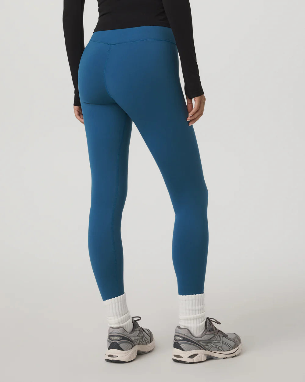 Person wearing blue leggings with a plain background
