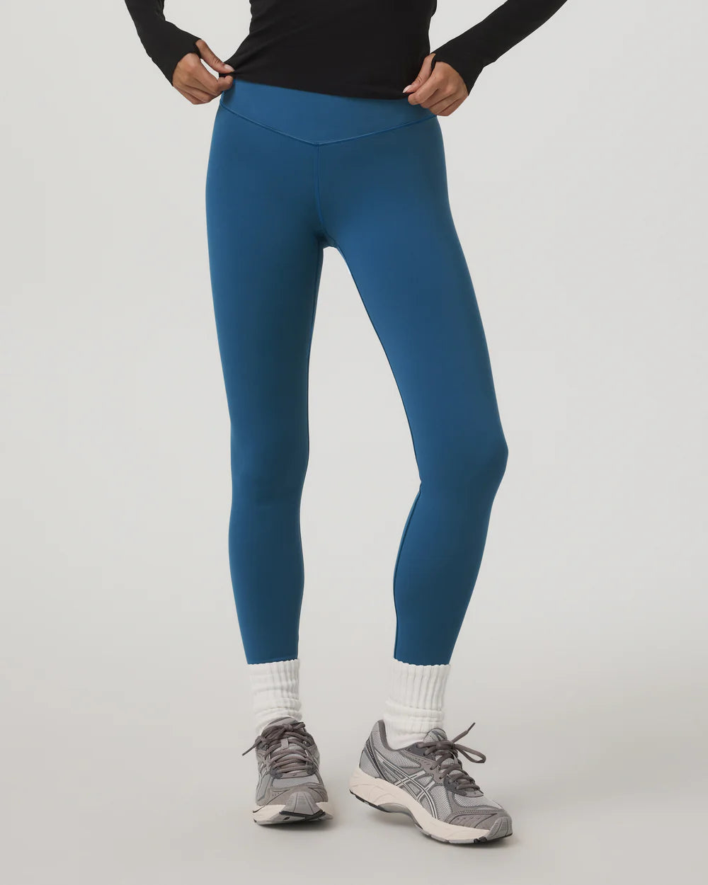 Person wearing blue leggings with a plain background