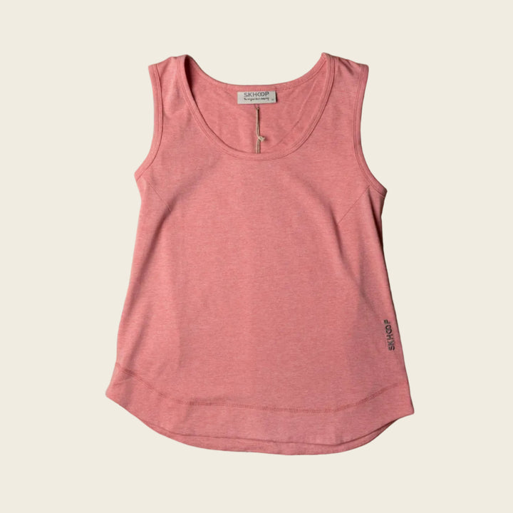 A pink, sleeveless tank top with a round neckline and rounded bottom hem, laid flat on a wooden surface.