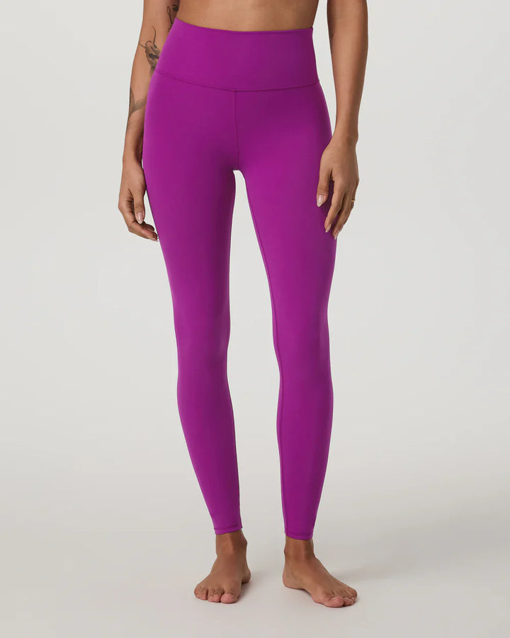 Person wearing bright purple leggings on a light gray background