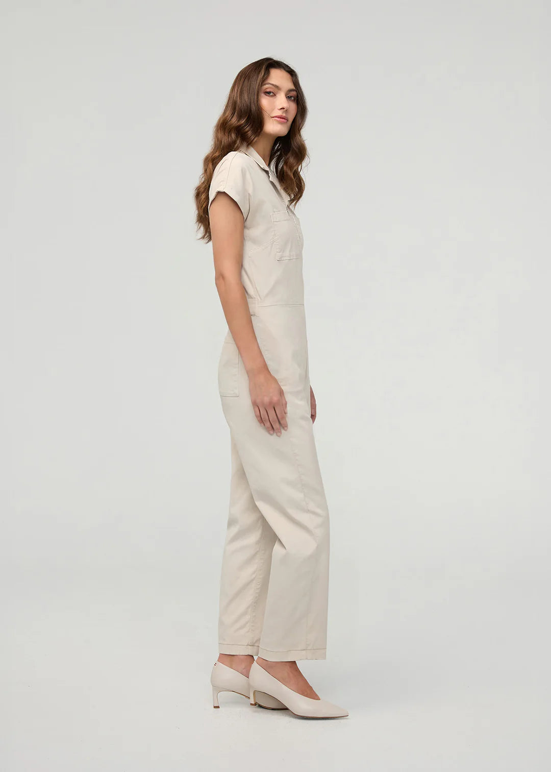 Woman wearing a beige jumpsuit on a white background