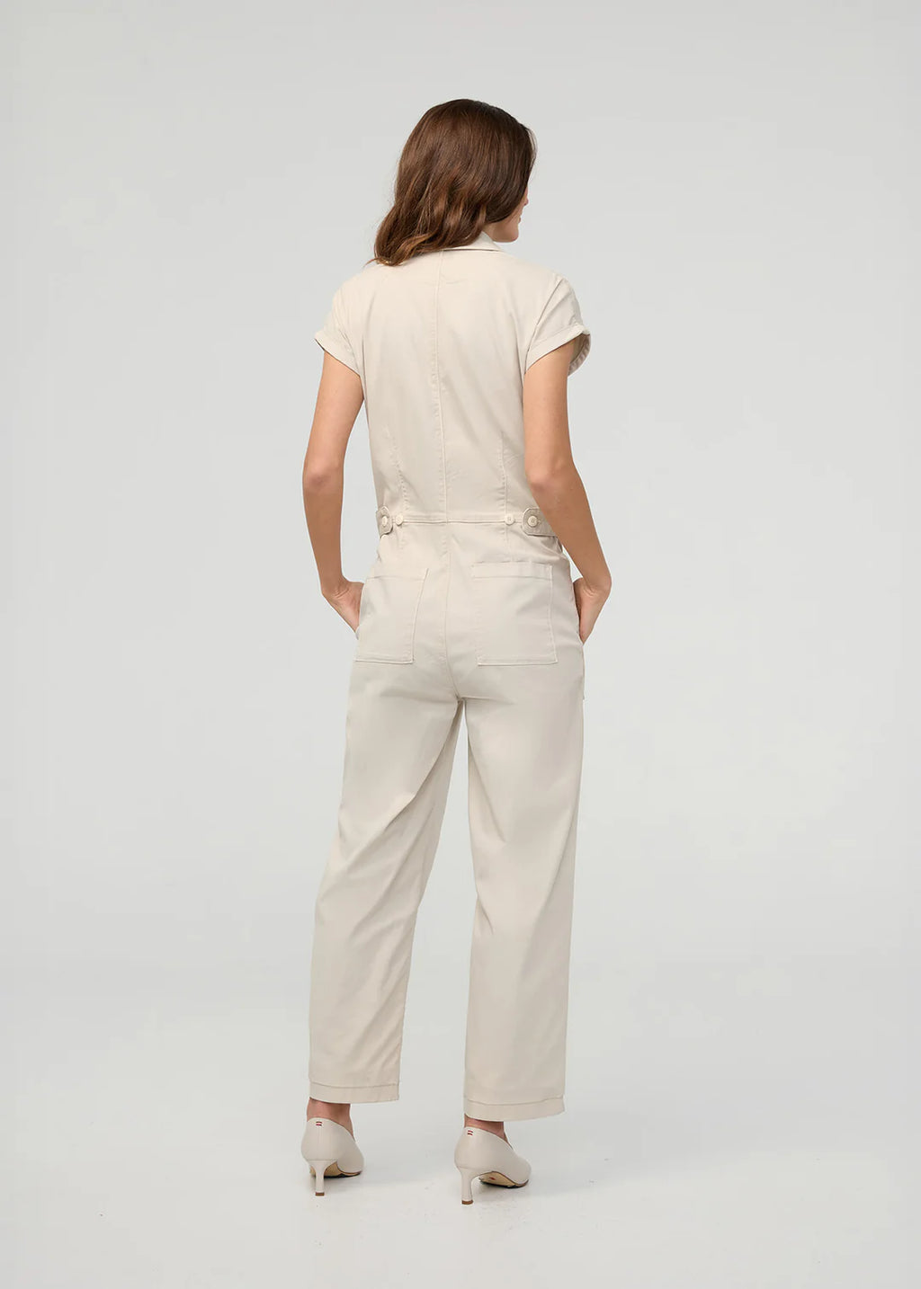 Woman wearing a beige jumpsuit on a white background